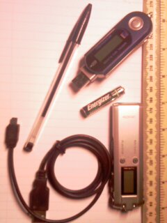 (Picture shows two voice recorders, one needing a data cable. Pen and AAA battery included for reference. The recorder on the left is marked 'digital MP3 player', which sort-of implies it's possible to have an MP3 player that's NOT digital: that might be difficult!)